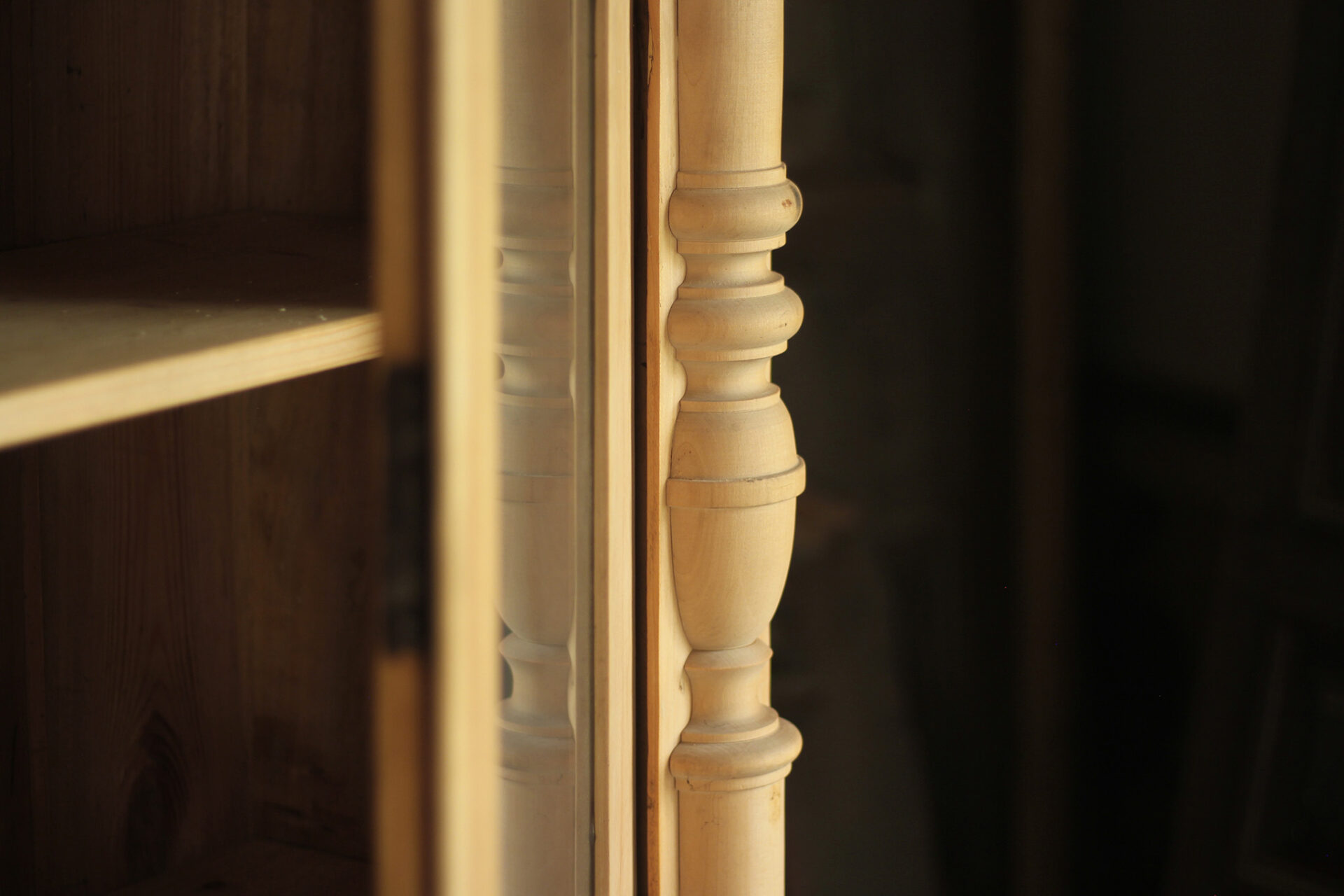 Toczona półkolumna drewnianej witrynki przed renowacją i drzwi z szybami.