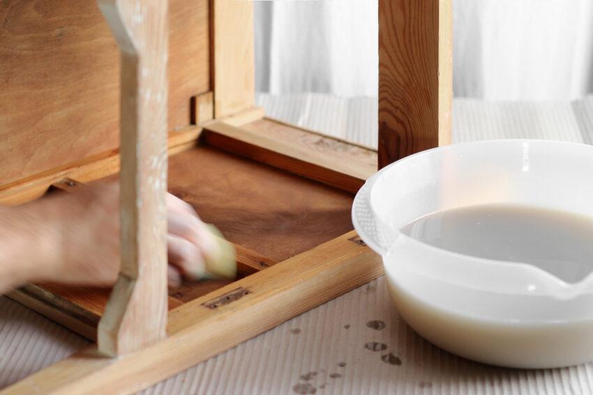 Mycie wnętrza drewnianej szafki wodą z mydłem.